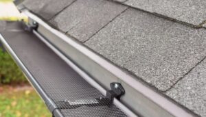 Close-up of seamless gutter system with mesh gutter guard preventing leaves and debris buildup