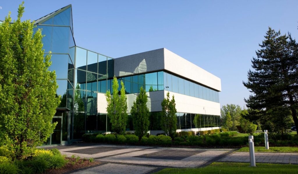 Commercial building with glass facade and surrounding landscape showing effective surface drainage design